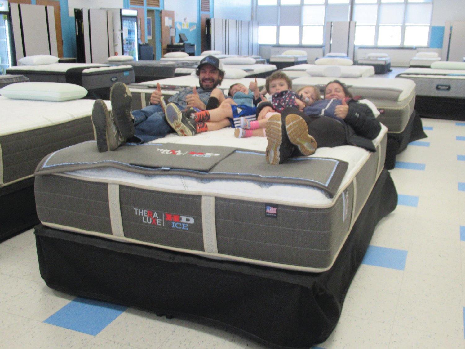 FIRM FUN: The Oakley family from Narragansett — Justin, Jamie, Zach, Miles and Fiona — offered a thumbs about this mattress they tried out Saturday during the JHS Music Department’s 5th Annual Mattress Sale.